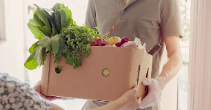 Man with Gloves Holding Box of Food for Donating