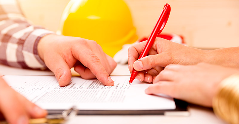 construcion workers hands pointing to paper plans