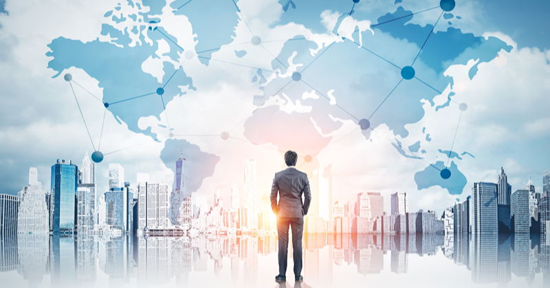 Businessman standing in front of an illustrated cityscape